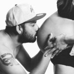 A couple sharing an intimate moment during pregnancy, highlighting love and parenthood.