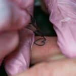 A woman getting a tattoo on her arm
