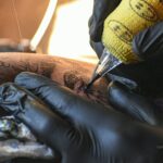 A man getting a tattoo on his leg