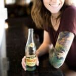 candid photography of woman holding bottle with broad smile
