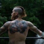 selective focus photography of topless holding on black rail during daytime