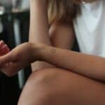 woman showing hear heart wrist tattoo
