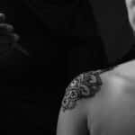 grayscale photo of woman with tattoo on her back